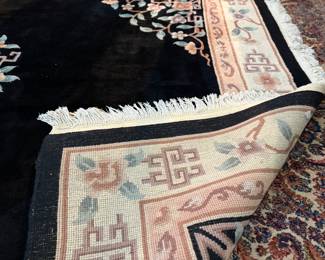This lot features a large hand-knotted Chinese wool rug with a black and beige floral medallion design. This rug measures, 148” H x 108” W.

