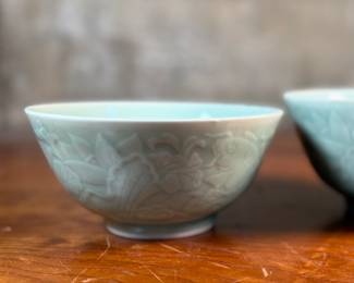This lot features a set of three (3) celadon bowls. The two on each side are matching and the one in the middle a tad larger, measuring 3.25” H x 6.5” W x 6.5” D. The bowl on the right has a tiny chip on rim that is photographed, but not noticeable.

