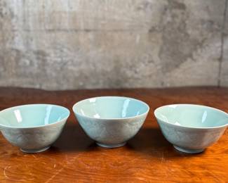 This lot features a set of three (3) celadon bowls. The two on each side are matching and the one in the middle a tad larger, measuring 3.25” H x 6.5” W x 6.5” D. The bowl on the right has a tiny chip on rim that is photographed, but not noticeable.

