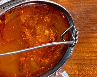 This lot features a stunning Baltic Amber in a sterling silver setting to be used as a brooch or pendant. This piece has a total approx. weight of 15.06 grams.

