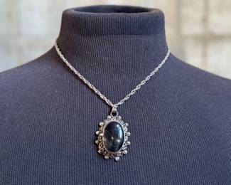 This lot features a "poison locket" pendant on a sterling silver chain measuring 18” with a total approx. weight of 34.31 grams.

