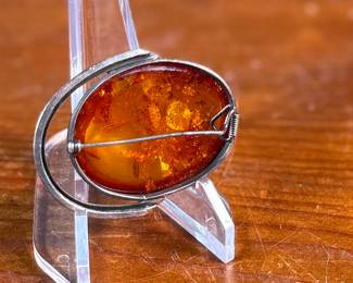 This lot features a stunning Baltic Amber in a sterling silver setting to be used as a brooch or pendant. This piece has a total approx. weight of 15.06 grams.

