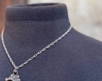 This lot features a "poison locket" pendant on a sterling silver chain measuring 18” with a total approx. weight of 34.31 grams.

