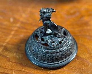 This lot features an Asian Koro, or incense burner, featuring a foo dog finial that measures, 7” H x 5” W x 5” D.

