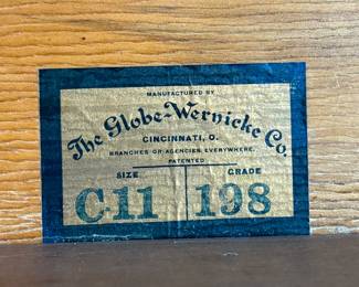 This lot features a stacking barrister bookcase manufactured by Globe Wernicke, dating back to the early 1900s. This bookcase in particular has a total of seven (7) pieces – 5 stacking bookcases, a base, and a topper. This piece measures from top to bottom, 75” H x 34” W x 11” D.

