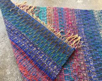 This lot features a beautiful handwoven, multi-color rug or wall art that measures, 35” H x 24.5” W.

