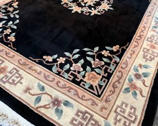This lot features a large hand-knotted Chinese wool rug with a black and beige floral medallion design. This rug measures, 148” H x 108” W.

