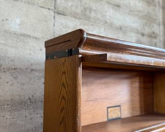 This lot features a stacking barrister bookcase manufactured by Globe Wernicke, dating back to the early 1900s. This bookcase in particular has a total of seven (7) pieces – 5 stacking bookcases, a base, and a topper. This piece measures from top to bottom, 75” H x 34” W x 11” D.

