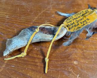 "Bad Spirit of the Mountain", an original carving by listed Alaskan artist, Adam John. Signed and titled on the verso circa 2002 and measures, 12” H x 5” W. Adam John is a noted Athabascan Native artist from Alaska, known for his traditional carvings, especially spirit masks and small sculptures, often depicting animals like owls or mountain spirits, and signed pieces can be found on art sites and auction platforms like eBay, continuing a heritage of Alaskan Native art. He’s associated with Central Alaska and his work is recognized for its cultural significance and craftsmanship. 

