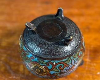 This lot features an Asian Koro, or incense burner, featuring a foo dog finial that measures, 7” H x 5” W x 5” D.

