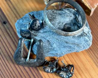This lot features a curated collection of antique sterling silver items including a bracelet, Taxco earrings, Siam cufflinks, & a belt buckle. Total approx. weight of 63.44 grams.

