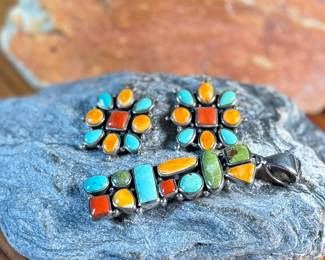 This lot features a stunning pair of Navajo earrings and a pendant made with sterling silver, turquoise, and spiny oyster shell jewelry. All items marked 925 with a total approx. weight of 26.82 grams. Signed by artist, "M".

