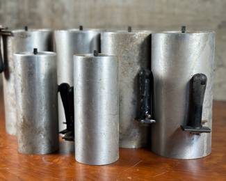 This lot features a set of six (6) cylindrical pendant lights, manufactured by Lightolier. The four larger lights measures, 8.5” H x 4” W x 4” D and the two smaller measure, 7” H x 3” W x 3” D. These lights could use some minor restoration prior to use. A beautiful set of authentic mid-century modern lighting. Lightolier was founded in 1904 by Bernhard Blitzer. Its original name was the New York Gas and Appliance Co., but it was changed to Lightolier, a combination of “light” and “chandelier, ” when electric lighting became more widely accepted.

