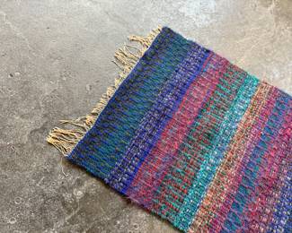 This lot features a beautiful handwoven, multi-color rug or wall art that measures, 35” H x 24.5” W.

