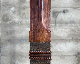 This lot features an incredible mahogany and copper sculpture by listed Oregon artist, Monica Setziol-Phillips. This piece sits in a custom iron base and measures, 75” H x 18” W x 13” D. Monica Setziol-Phillips has a B.A. degree in foreign languages from Portland State University. Monica who is married to Oregon Shakespeare Festival actor, Josiah Phillips, and daughter of well rememberd sculptor, Le Roy Setziol has been weaving for over 35 years and carving for over 20 years. Her work is in many private collections in many states. She also has work in puplic spaces, most recently three of her pieces were chosen for The Allison, the new resort in Newberg. In October of 2009 Monica finished a major work for the new Civic Hall in McMinnville, Oregon. For a number of years she has participated in the Sitka Art Invitational.

