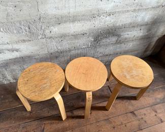 This lot features a set of three Artek Nesting Stools (model E60) in natural birch veneer, designed by Alvar Aalto. Each stool measures, 17” H x 13.5” W x 13.5” D. Designed by Alvar Aalto in 1933, the stools are a classic of Finnish modernism. They feature a patented L-shaped bent-leg construction, which makes them sturdy and easily stackable. 

