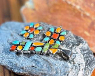 This lot features a stunning pair of Navajo earrings and a pendant made with sterling silver, turquoise, and spiny oyster shell jewelry. All items marked 925 with a total approx. weight of 26.82 grams. Signed by artist, "M".

