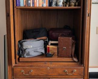 wood entertainment center, binoculars, books