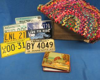Lot 323. Vintage tin, braided rug, 7 license plates, and a wooden box