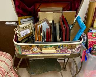 Empty picture frames, luggage stand and vintage decoupage decorated suitcase