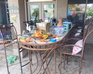 Bar-height outdoor patio table with wrought-iron base. Comes with 8 chairs. 
