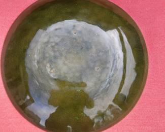 Additional view of the reverse, highlighting the deep greenish-black overfired enamel and natural copper patina typical of Saara Hopea’s studio pieces. The sky reflection beautifully reveals the iridescent oxidation and subtle metallic flashes from multiple kiln firings.