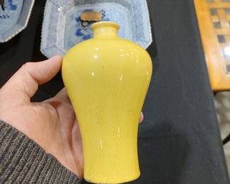 Monochrome Yellow-Glazed Vase (Meiping Form)

China, Qing dynasty style
18th–19th century (attribution)

Porcelain vase with a gracefully swelling body and gently tapering neck, inspired by the classical meiping form. The vessel is covered in a rich monochrome yellow glaze, evenly applied with a soft, luminous surface and subtle pooling toward the foot. The unglazed foot rim reveals firing grit and wear consistent with age and handling.