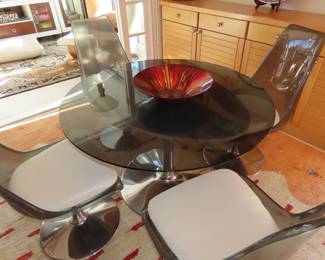 Smoked glass table with smoked plastic/fibreglass tulip chairs.