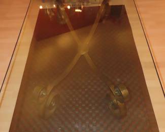 Leather area rug under a large glass and iron coffee table.