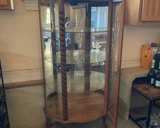 R276 - $95. Oak Bow Front Cabinet. Measures 34" wide x 15.5" deep x 58" tall. Top Curved Trim on the right side is cracked. All Glass is intact! Key is included. It does wiggle a little and needs some work. 