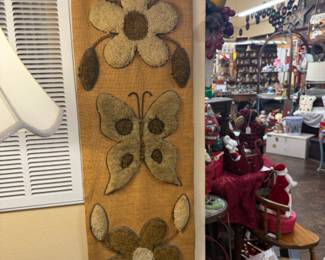 Vintage 1970s latch hook textile wall hanging on burlap with floral and butterfly pattern
