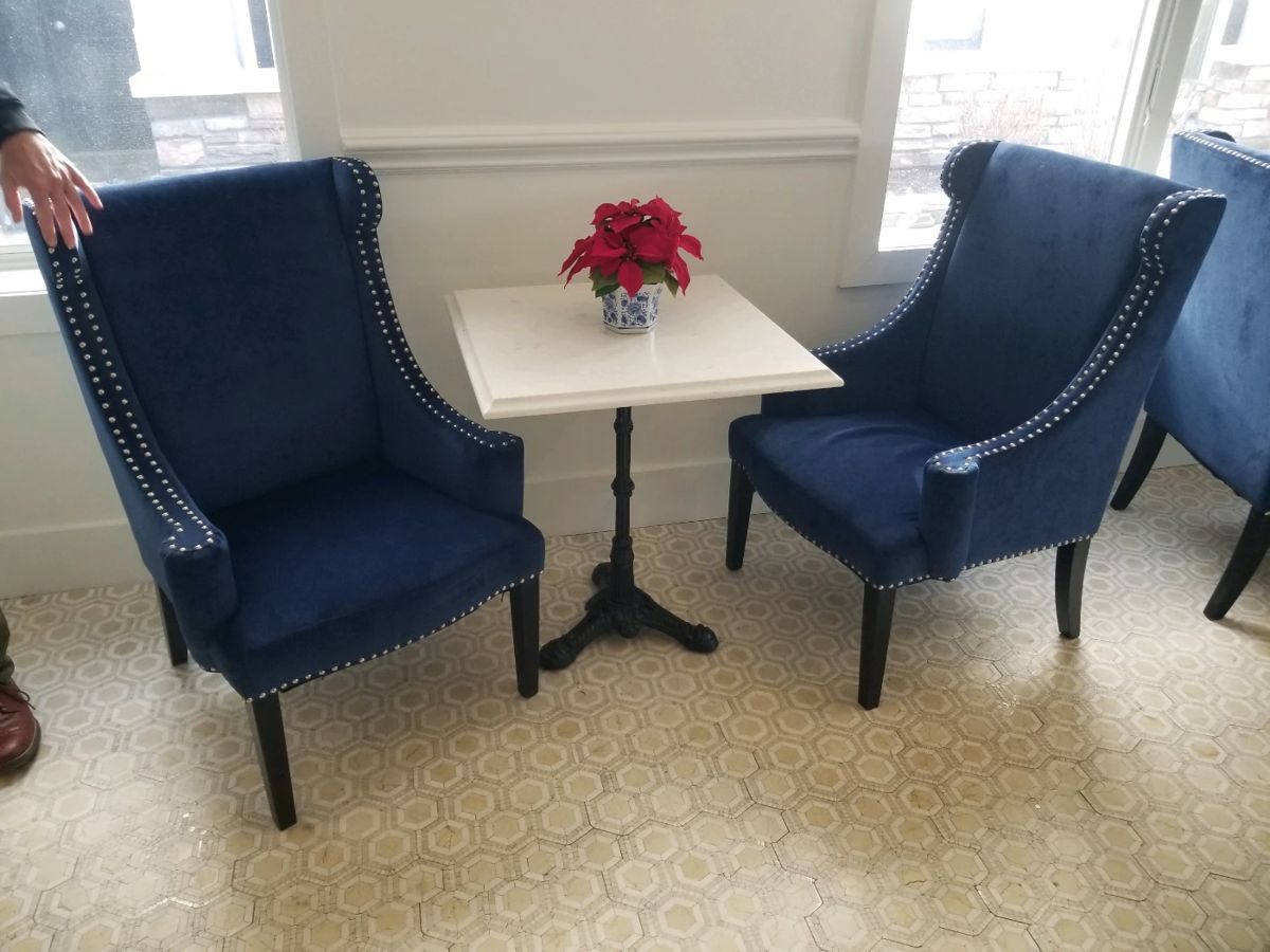 Upholstered chairs with studs - 6 chairs available. Marble top square tables with wrought iron bases - 7 tables available