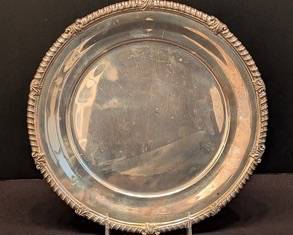 Vintage Tiffany & Co Sterling Silver Plate

Offered is an elegant Tiffany & Co sterling silver plate measuring 10.5 inches in diameter and weighing 664 grams. This round plate features a detailed ornate border and is hallmarked on the reverse with 'TIFFANY & CO MAKERS' and 'STERLING SILVER 17878.' The back also includes a personalized engraved dedication with dated inscriptions.

Features:
Sterling silver construction
Ornate decorative border
Tiffany & Co hallmarks on reverse
Personalized etched dedication on back
Diameter: 10.5 inches
Weight: 664 grams