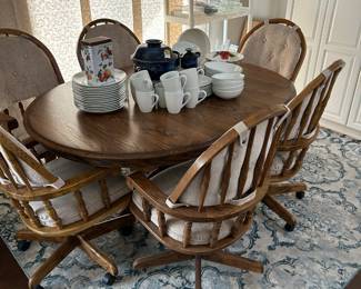Round Oak Table with inside leaf, 6 swivel rocking chairs on wheels