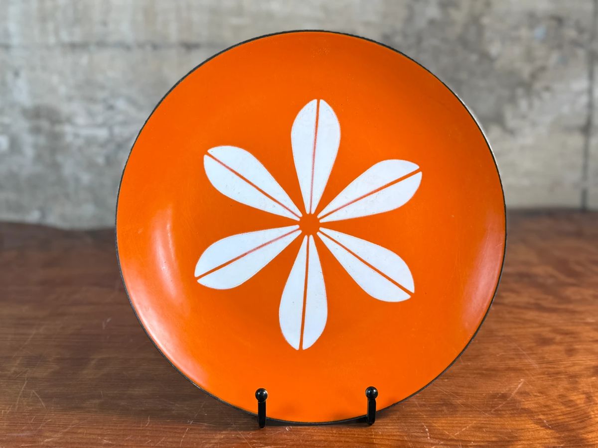 This lot features a vintage Cathrineholm orange Lotus plate, designed by Norwegian artist, Grete Prytz Kittelsen circa 1960s. This Lotus plate measures 10.25” H x 10.25” W.


