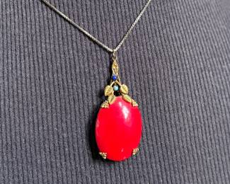 This lot features an antique sterling silver necklace with a red coral pendant. This necklace measures, 18”.

