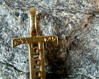 This lot features a 14k gold cross pendant with genuine diamonds and a total approx. weight of .41 grams.


