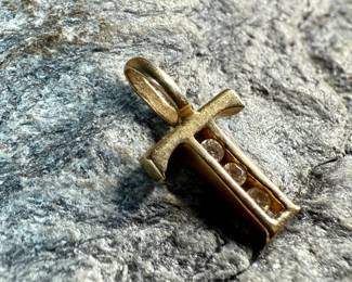 This lot features a 14k gold cross pendant with genuine diamonds and a total approx. weight of .41 grams.

