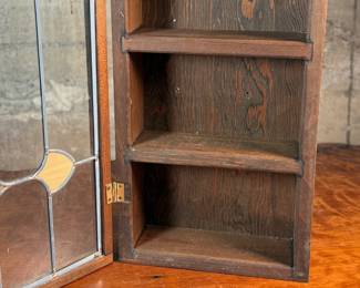 This lot features an antique spice cabinet with a stained glass door that measures, 22.5” H x 9.5” W x 4” D.

