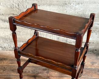 This lot features an antique English mahogany two-tier trolley or serving table, possibly Victorian era that measures, 30” H x 24” W x 16” D.

