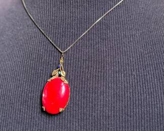 This lot features an antique sterling silver necklace with a red coral pendant. This necklace measures, 18”.

