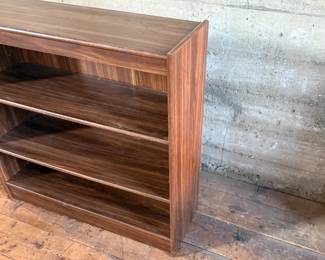 This lot features a three-shelf bookcase with a walnut veneer that measures, 36” H x 36” W x 12” D.

