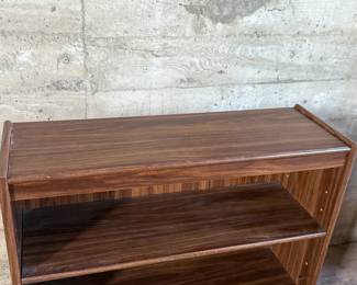 This lot features a three-shelf bookcase with a walnut veneer that measures, 36” H x 36” W x 12” D.

