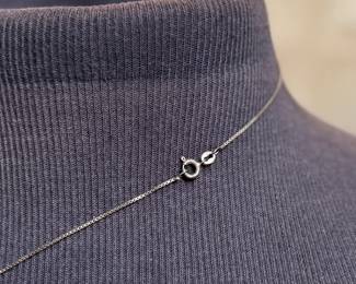 This lot features an antique sterling silver necklace with a red coral pendant. This necklace measures, 18”.

