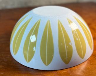 This lot features a vintage Cathrineholm Lotus enamelware bowl in white with a yellow (or mustard) leaf pattern. The design is a classic example of Mid-Century Modern Norwegian design. The bowl form and colors were created by designer Grete Prytz Kittelsen, while the iconic lotus pattern is attributed to Arne Clausen.

