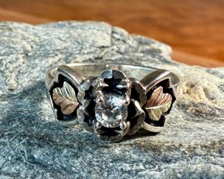 This lot features a beautiful ring crafted with sterling silver and 18k gold. It has a cz diamond, comes in a size 8, and has a total approx. weight of 4.69 grams.

