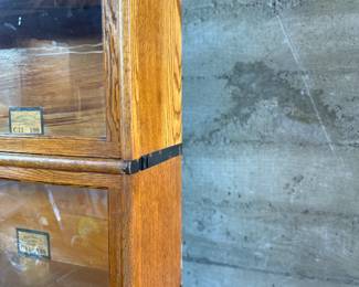 This lot features a stacking barrister bookcase manufactured by Globe Wernicke, dating back to the early 1900s. This bookcase in particular has a total of seven (7) pieces – 5 stacking bookcases, a base, and a topper. This piece measures from top to bottom, 79” H x 34” W x 11.5” D.

