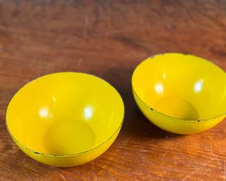 This lot features a pair of vintage Finel yellow enamel bowls, likely designed by Kaj Franck for the Finnish company Finel/Arabia during the 1950s or 1960s. Each bowl measures, 2.75” H x 6.25” W x 6.25” D.


