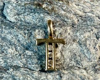 This lot features a 14k gold cross pendant with genuine diamonds and a total approx. weight of .41 grams.

