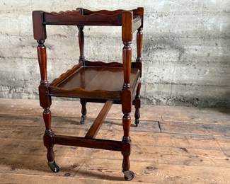 This lot features an antique English mahogany two-tier trolley or serving table, possibly Victorian era that measures, 30” H x 24” W x 16” D.

